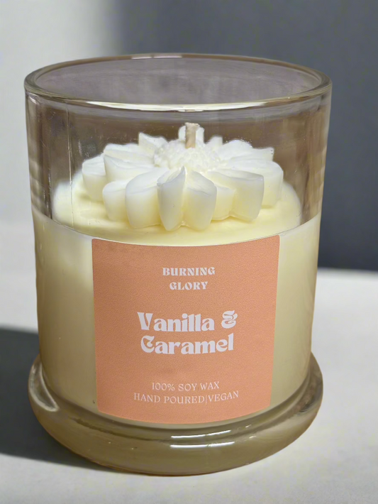 Vanilla & Caramel candle in a glass jar with a label on a wooden surface.