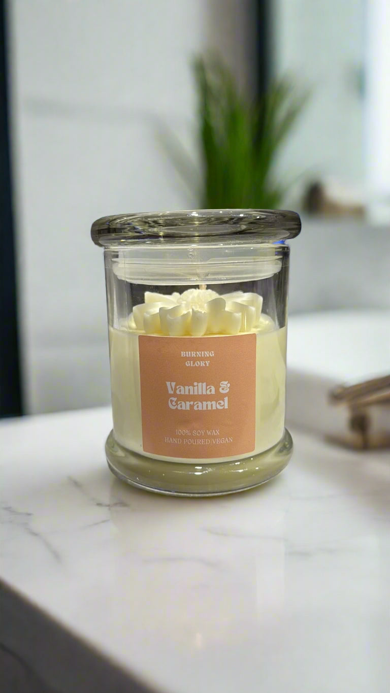 Jar candle labeled 'Vanilla & Caramel' on a surface with a blurred background